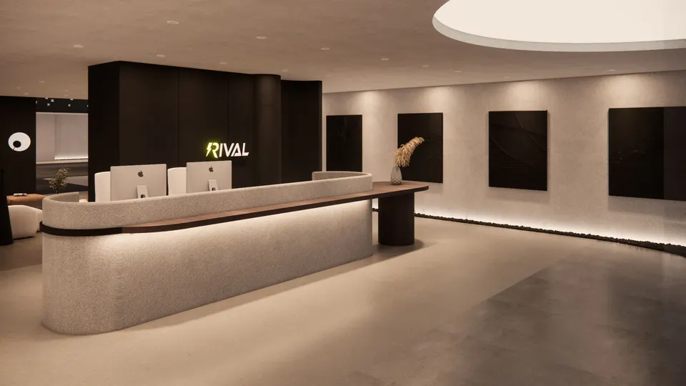 Reception desk seen at an angle, with the lit sign behind and dark panels along the wall