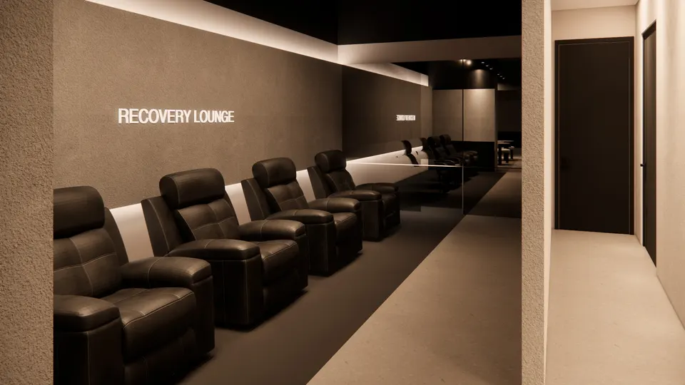 Recovery lounge with a row of dark leather recliners along a lit wall