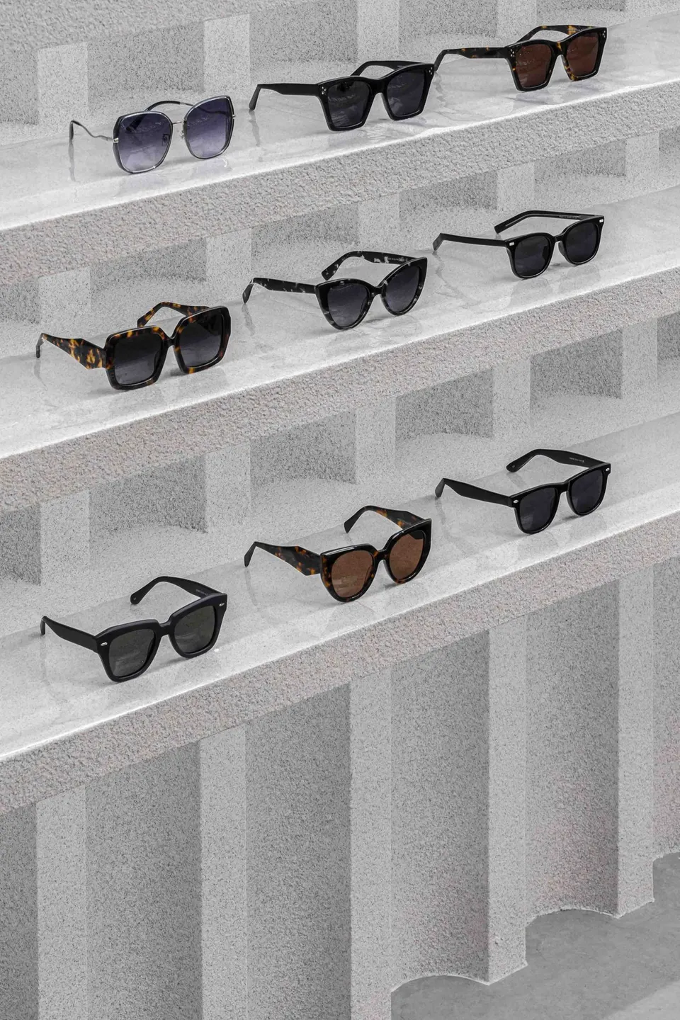 Sunglasses on textured plaster shelves, close up