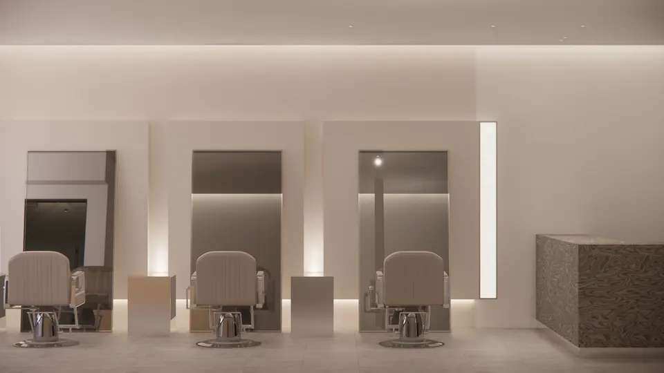 Three styling chairs facing tall leaning mirrors set in lit wall panels