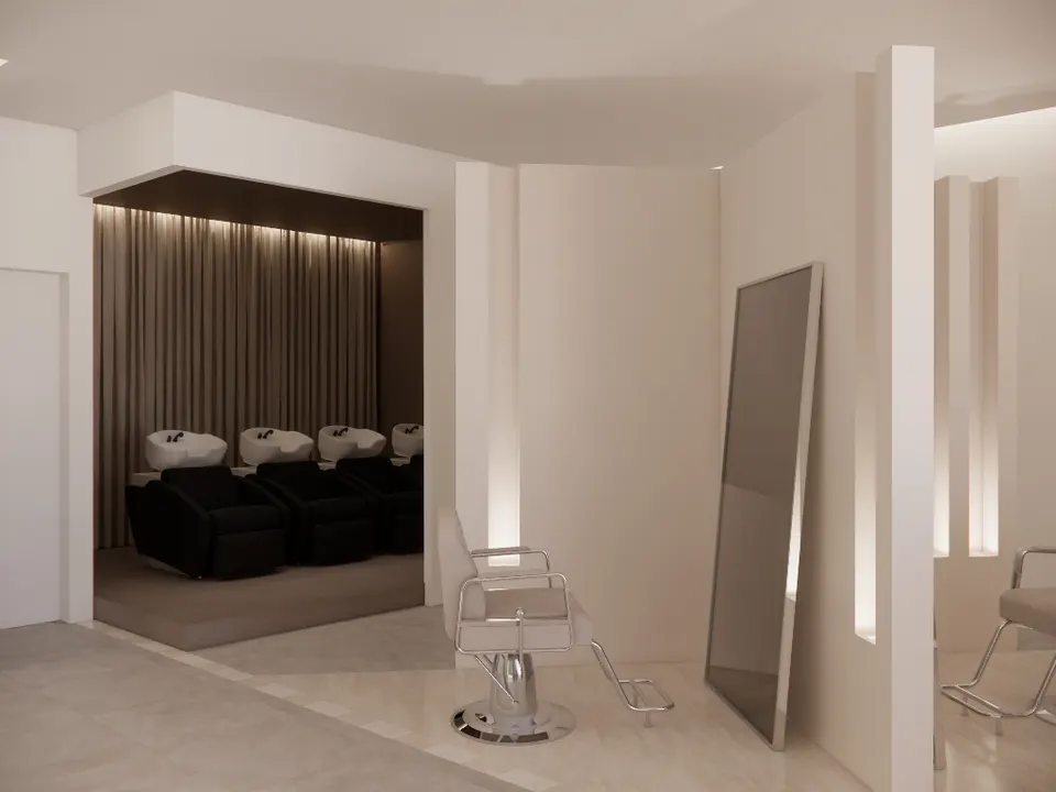 Row of wash basins and black recliners in front of a lit curtain