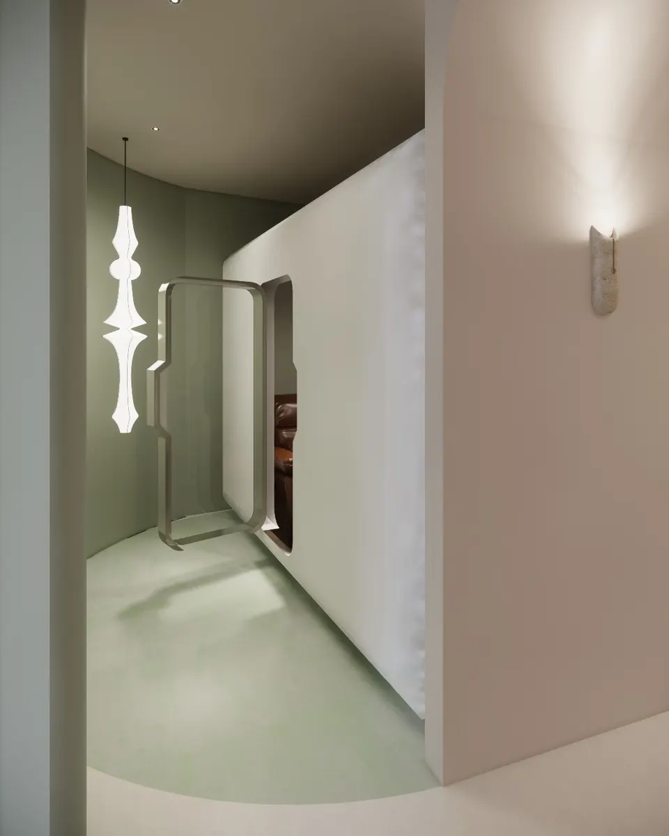 Rounded door standing open beside a sculptural pendant light