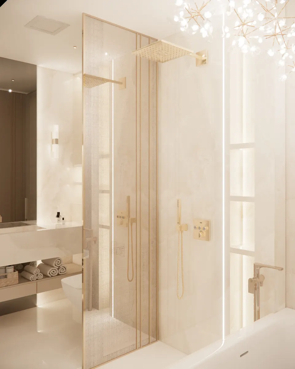 Shower with brass fittings behind a bronze glass screen