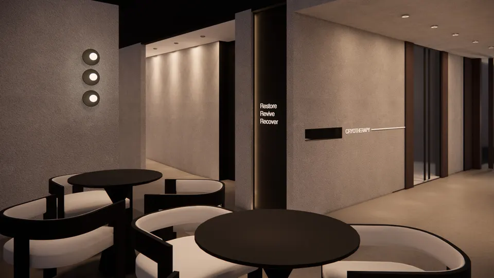 Café tables and curved chairs beside a plaster wall with lit signage