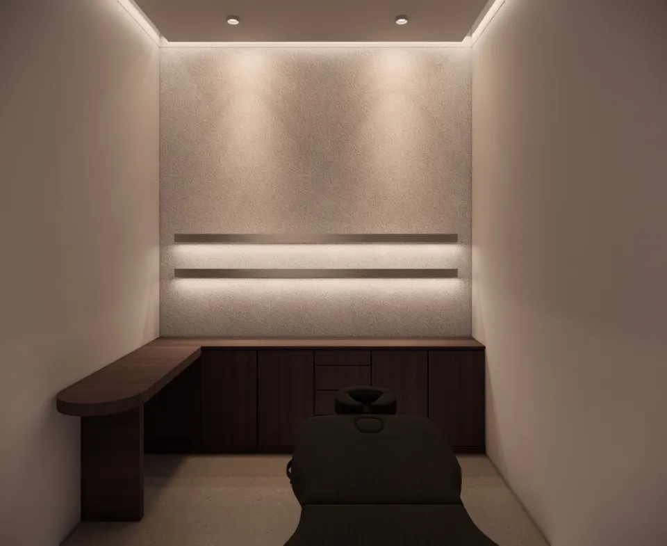 Treatment room with a dark timber counter and a softly lit plaster wall